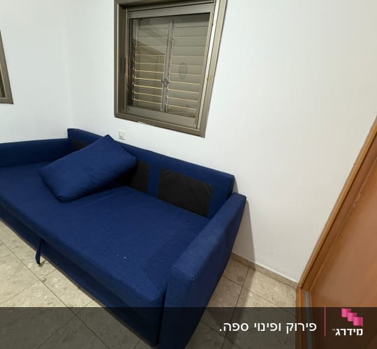 ספה כחולה ליד חלון עם תריסים